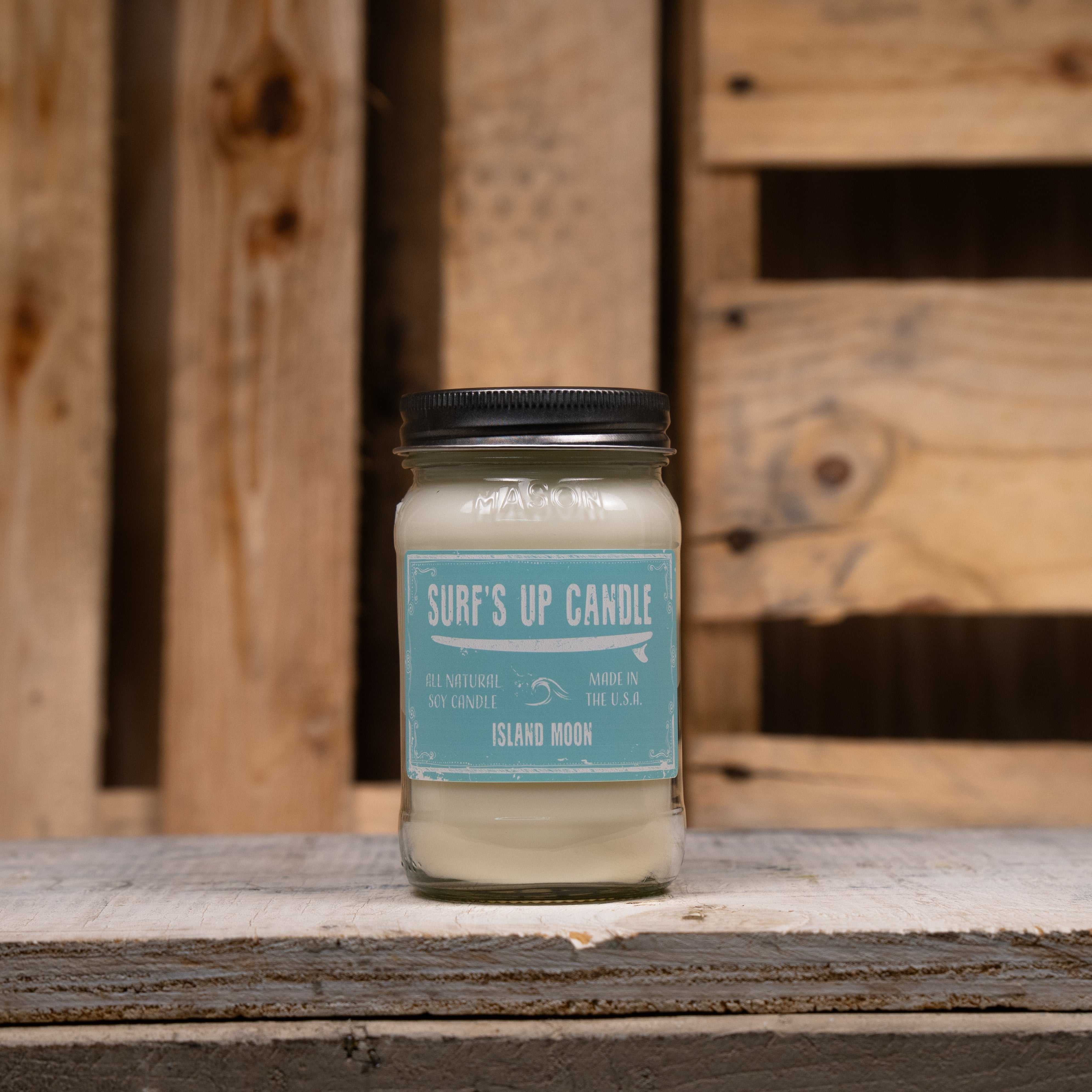 Candle in a glass jar with a blue label on a wooden surface
